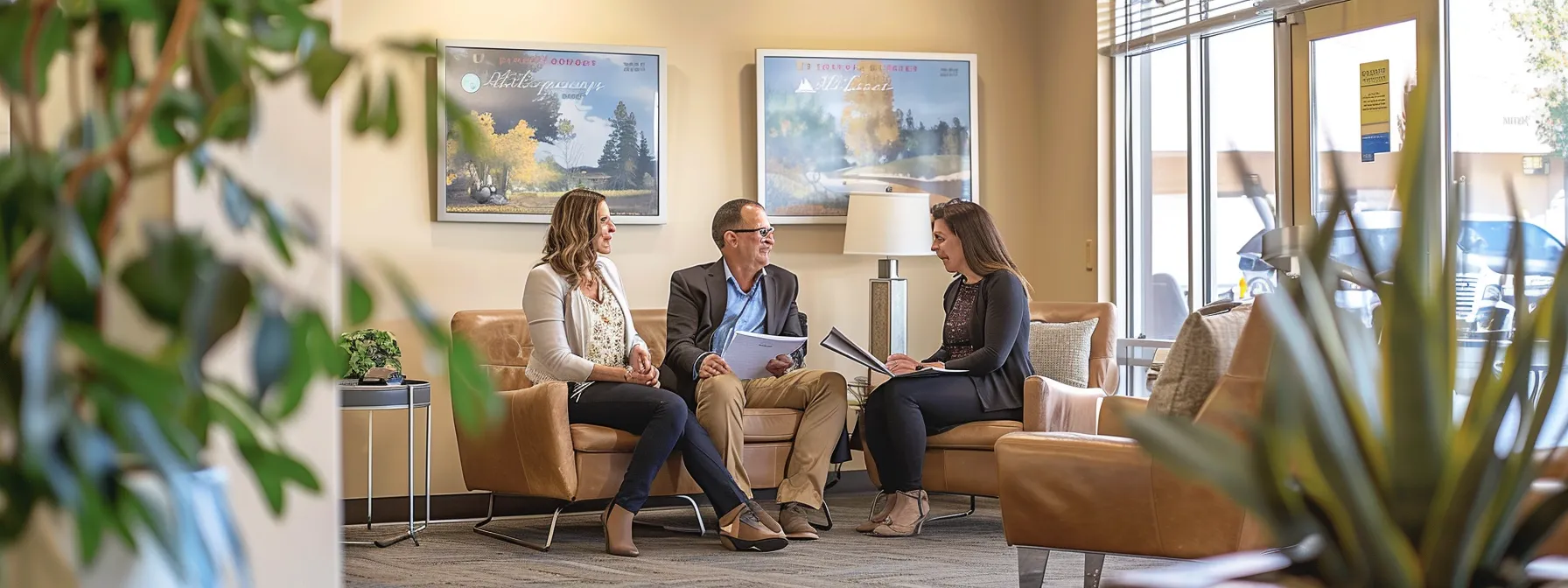 a couple consulting with a real estate agent in a bright, welcoming office, discussing contracts and paperwork for their new home purchase in st. george.