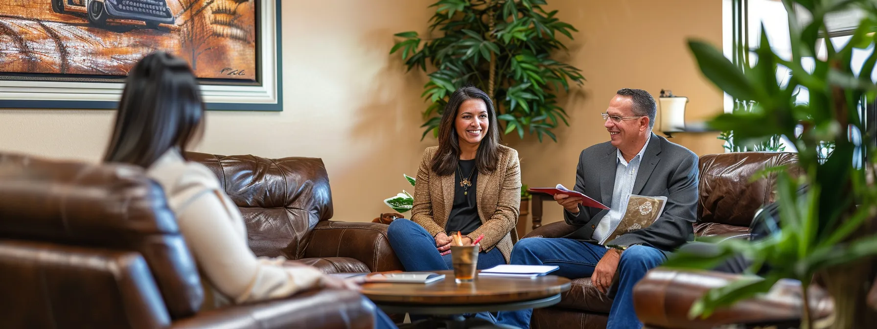 a couple meeting with a knowledgeable and friendly mortgage lender in a cozy office in st. george, discussing rates and fees for their dream home.