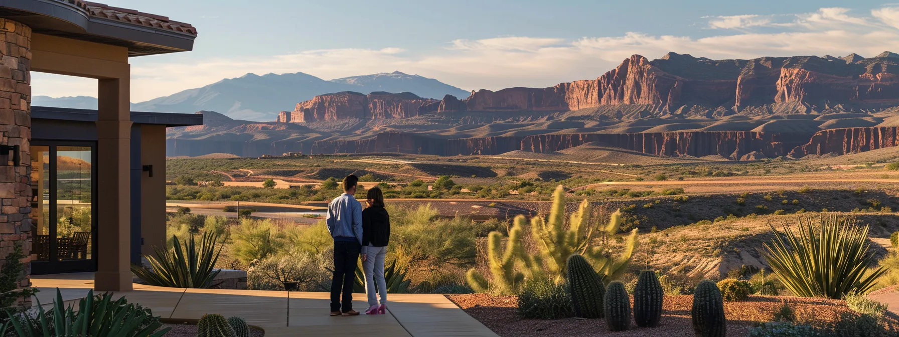 a couple standing with a trustworthy st. george real estate agent in front of a beautiful desert landscape property.