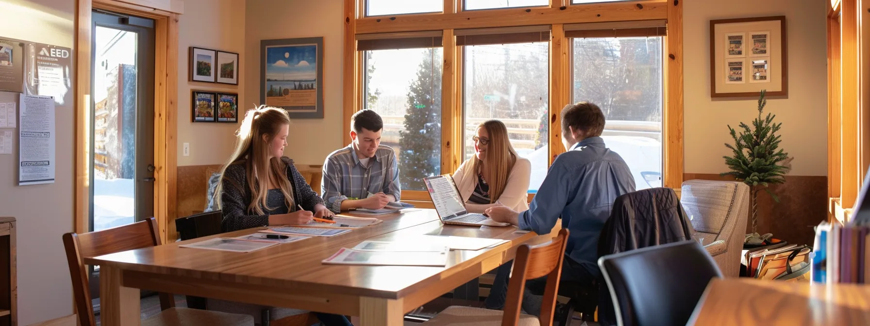 a young couple enthusiastically reviewing financial documents with a loan officer and real estate agent at a cozy office in st. george.